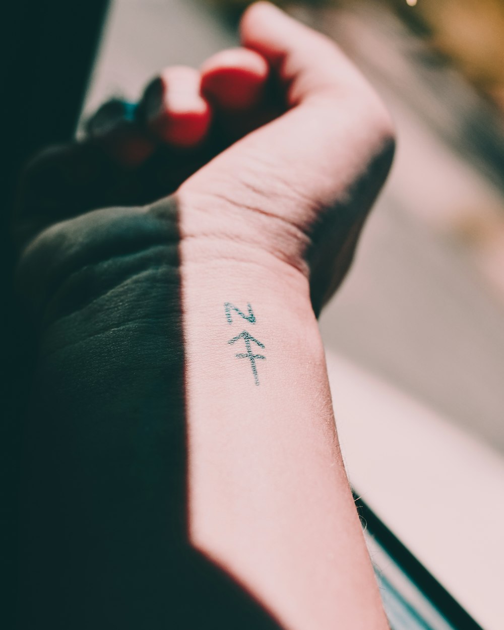 selective focus photography of person showing wrist tattoo