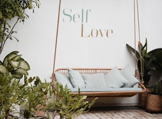 brown rattan swing bench with cushions