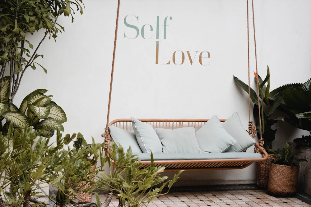 brown rattan swing bench with cushions