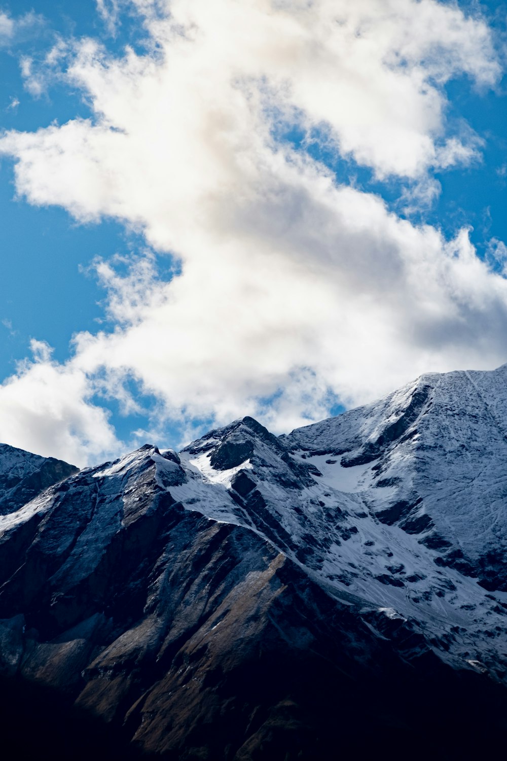 mountain covered with snow under white and blue sky during daytime