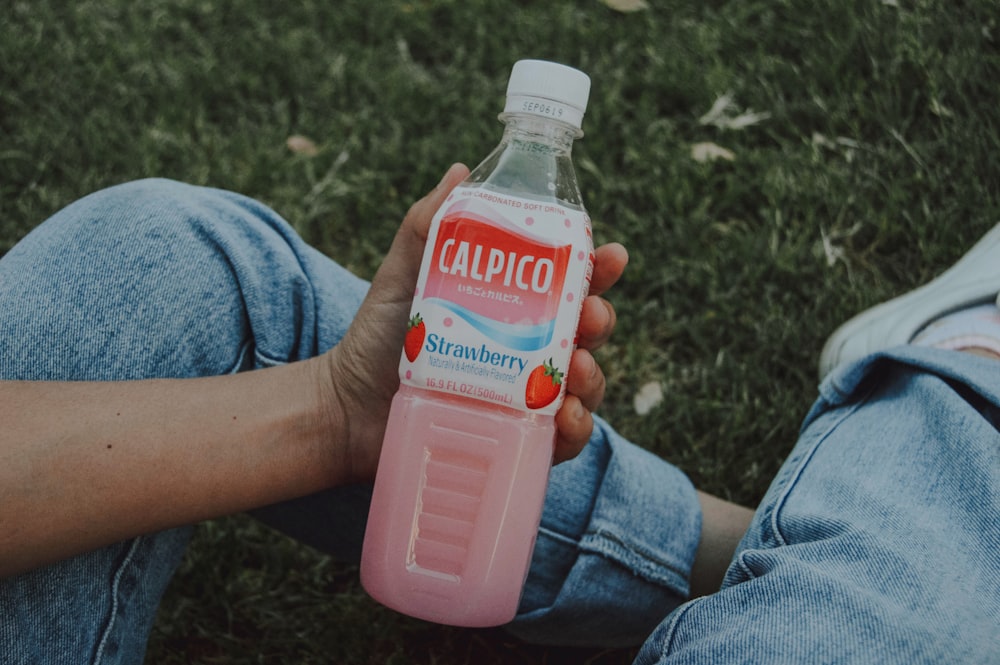 person holding Calpico strawberry bottle