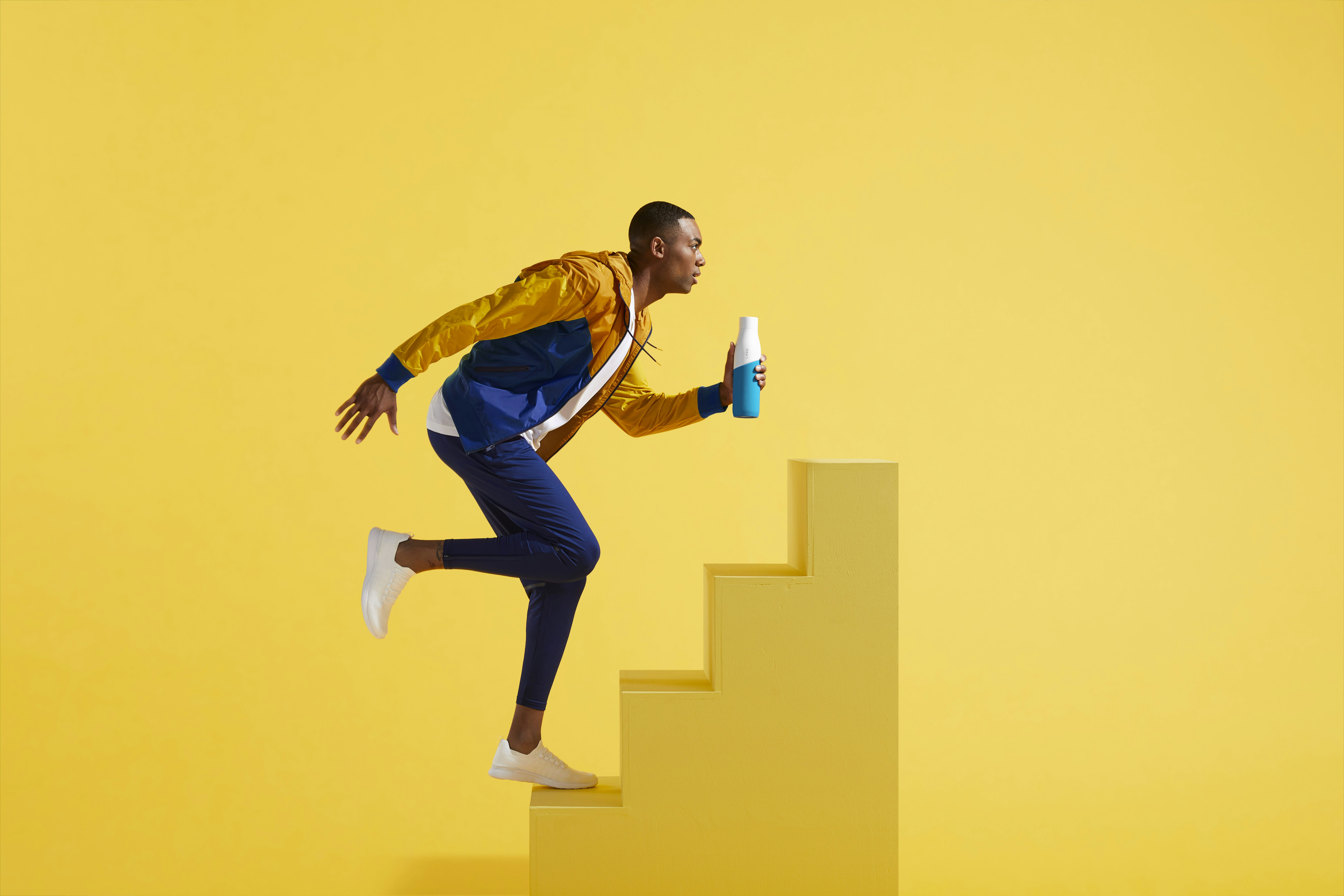 man in blue and yellow jacket and blue pants on yellow stair