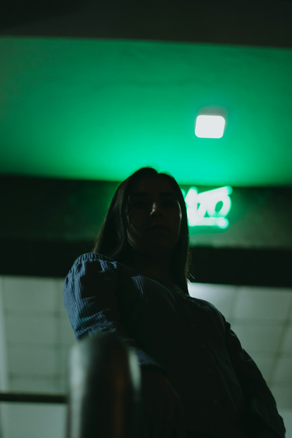 a woman standing in front of a green light