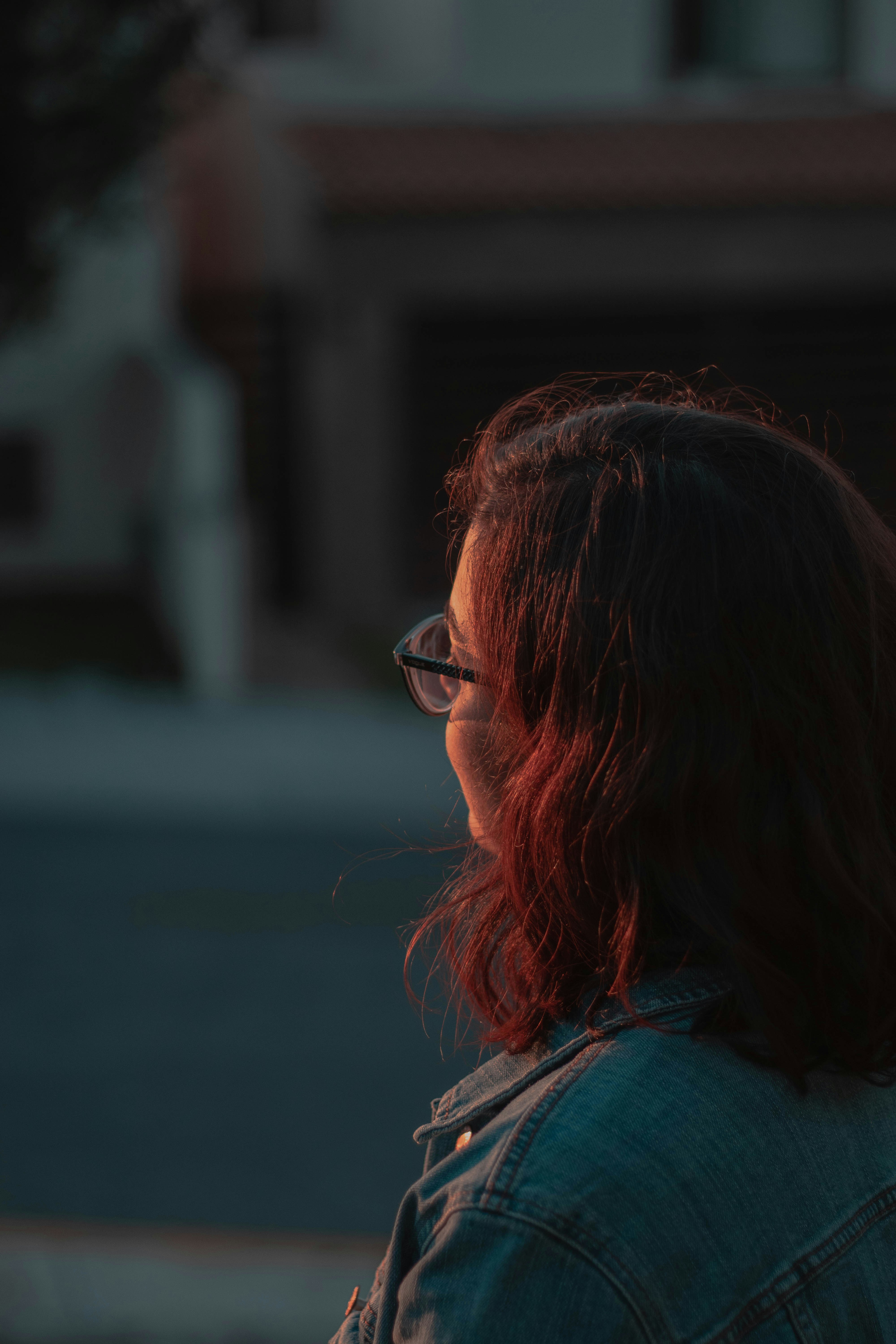 woman wearing blue denim jacket and eyeglasses during daytime