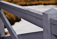 A close-up of a freshly painted fence in a residential backyard.