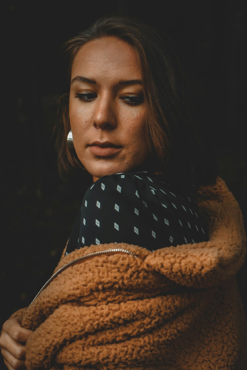 a woman wrapped in a blanket looking down