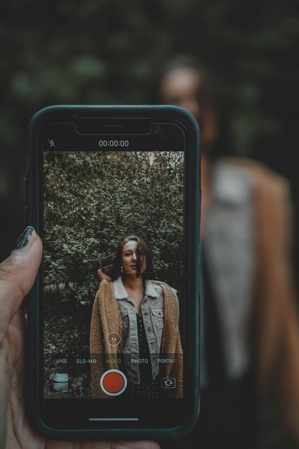 person taking photo of a woman using iPhone