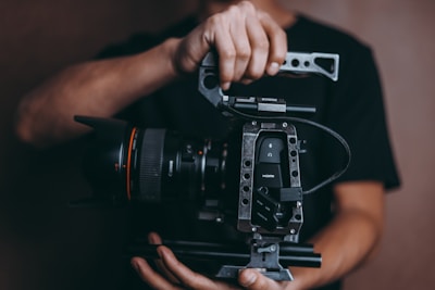 person holding DSLR camera with stabilizer