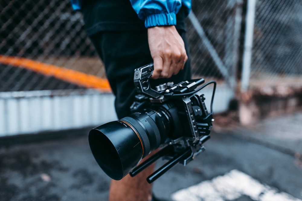 person carrying black video camera