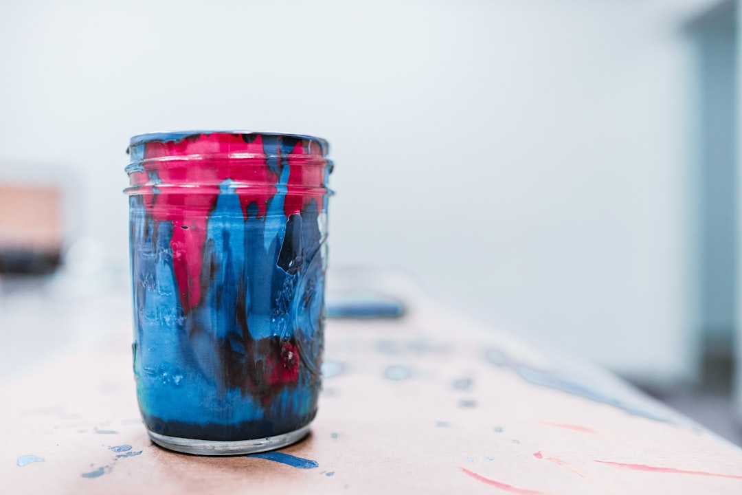 blue and red paint jar on white surace