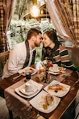 A couple exchanging warm glances over a candlelit dinner table.