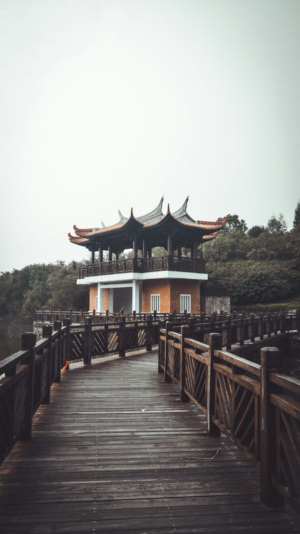 empty walkway by pagodaunder white sky