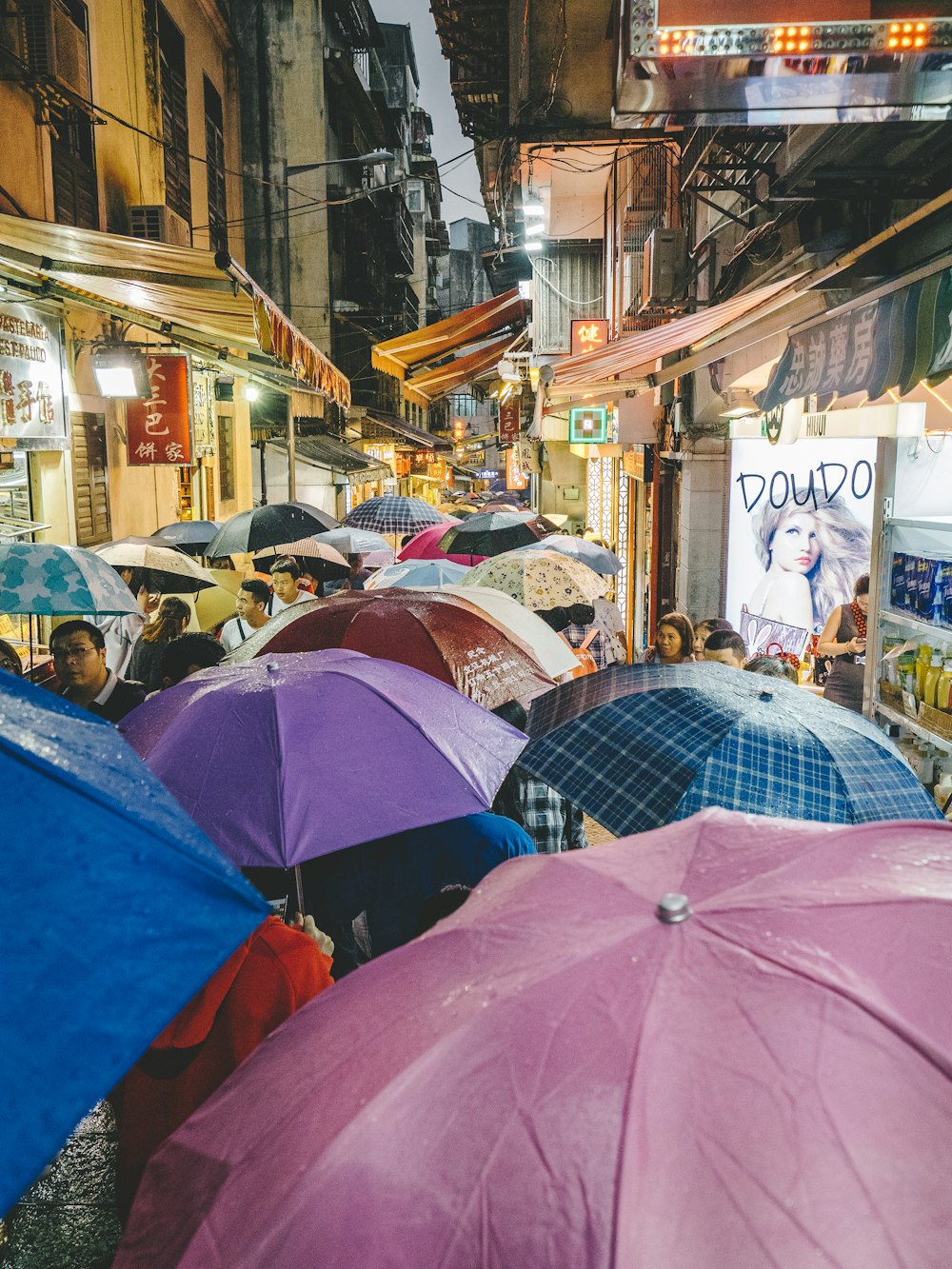 people using umbrella walking in the rain at the walkway