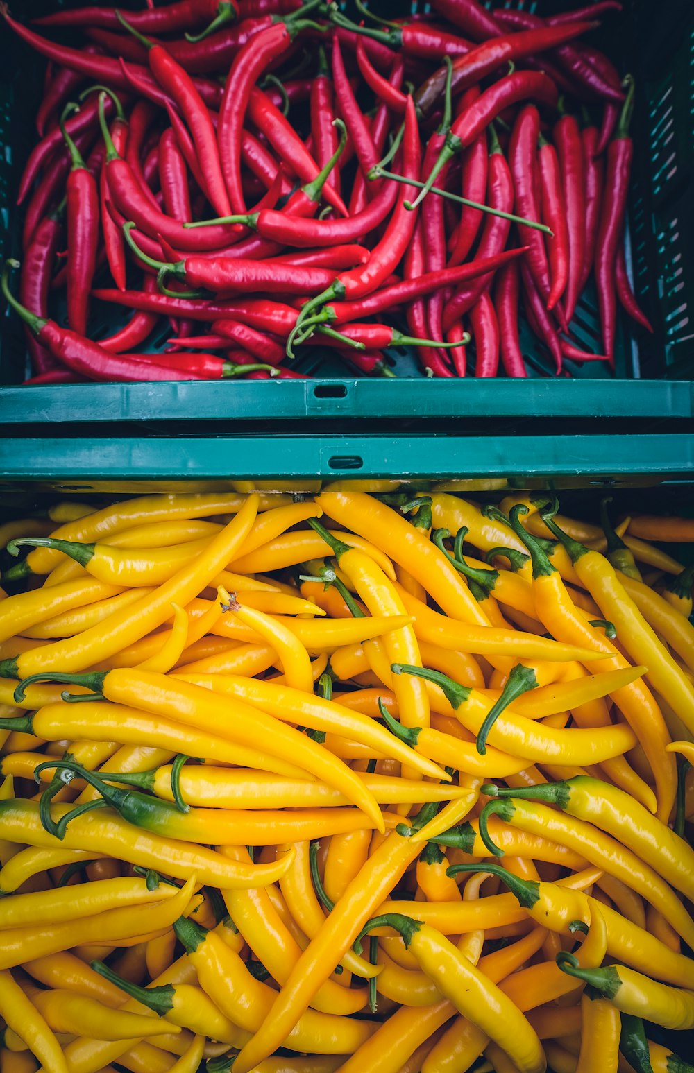 yellow and red chilis on plastic crate