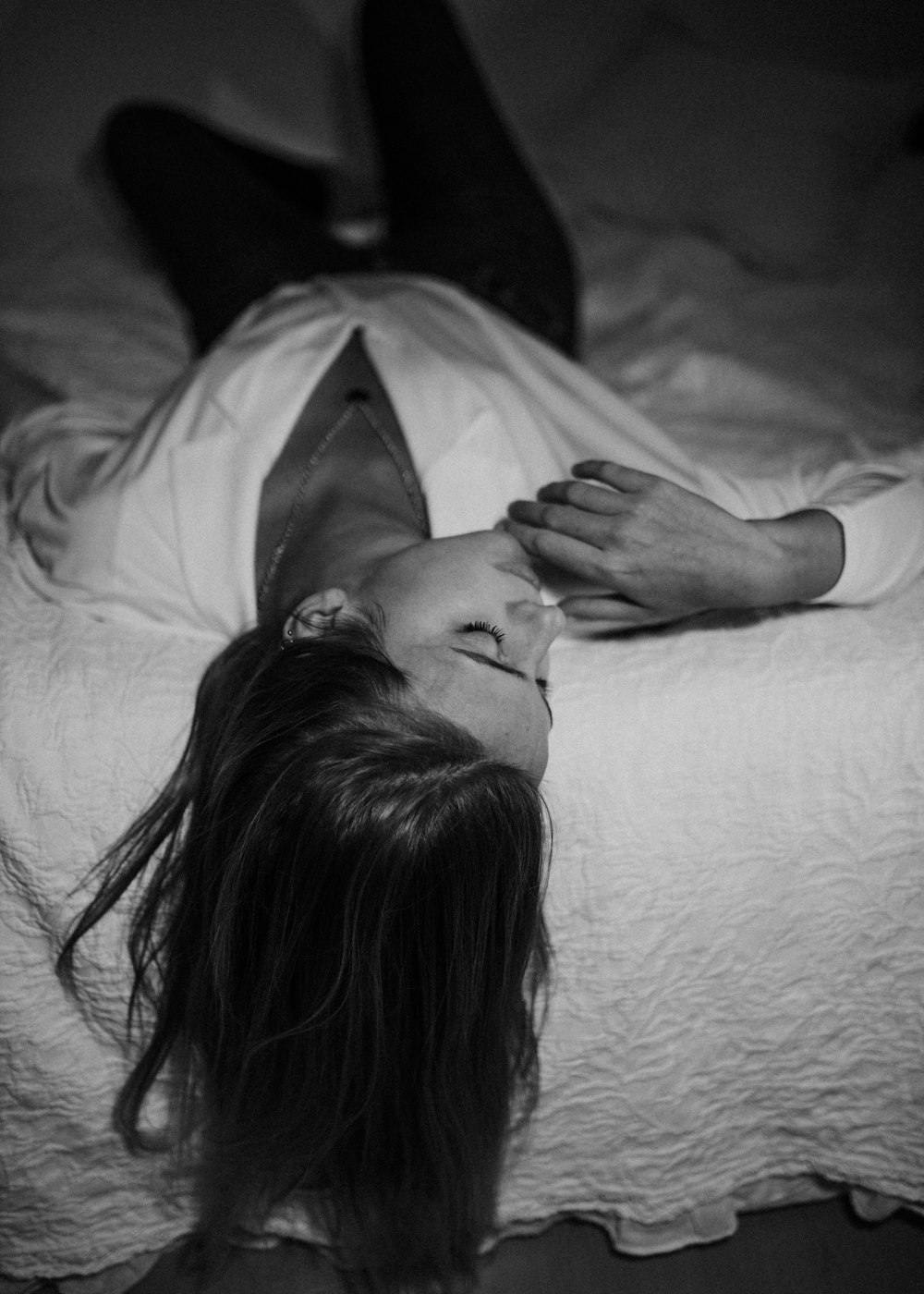 gray-scale photo of woman laying on bed