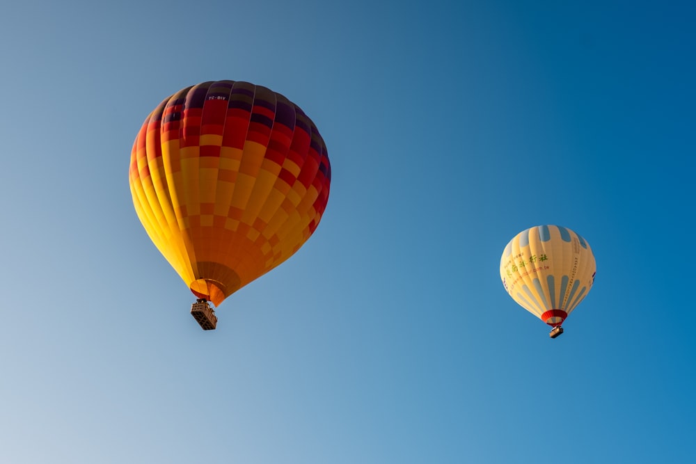 two assorted-colored hot air balloon in the sky during daytime