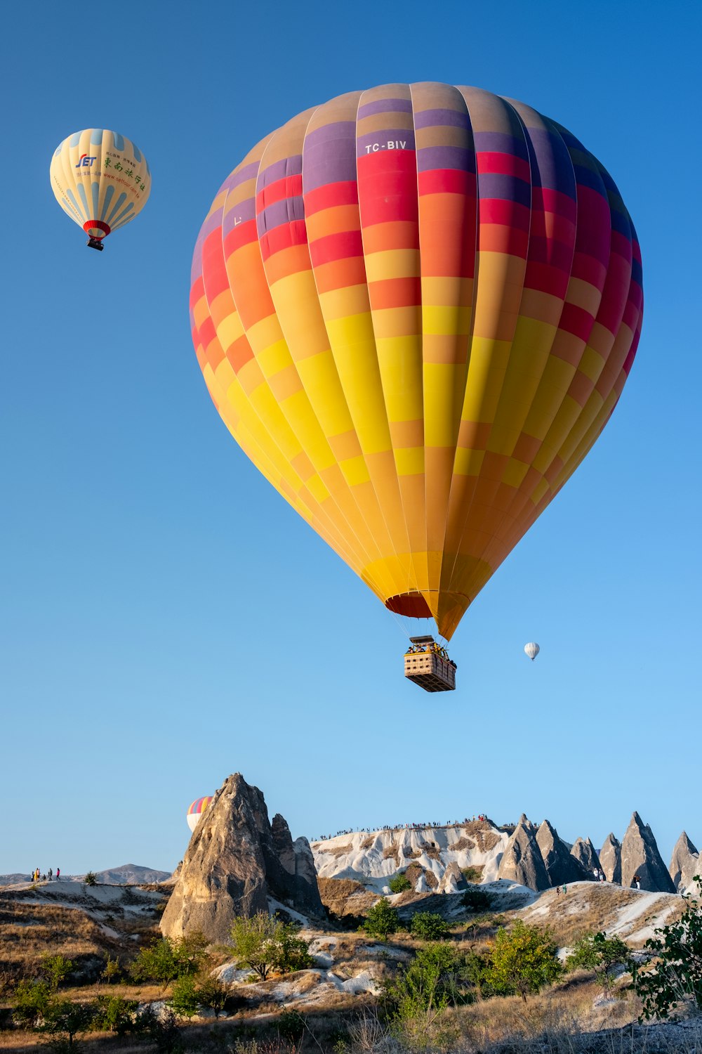 three multicolored hot air balloons above mountain during daytime