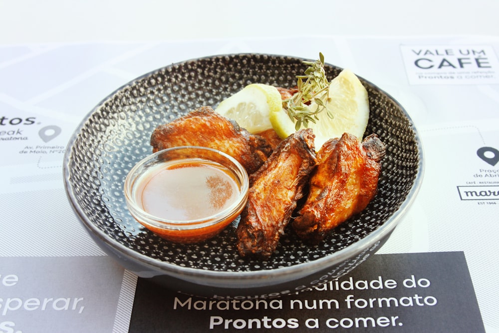 a plate of food that includes chicken wings and a dipping sauce