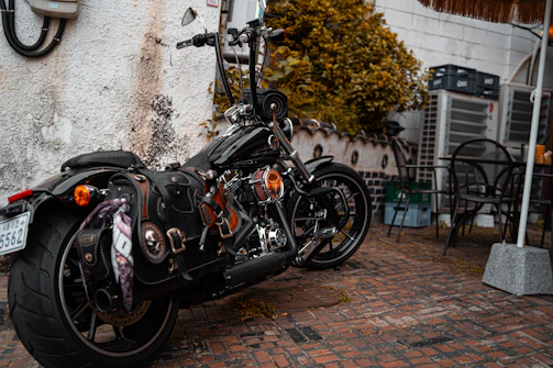 A collection of colorful motorcycle saddlebags hanging on a rustic fence