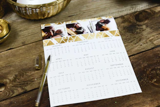 black ballpoint pen near calendar