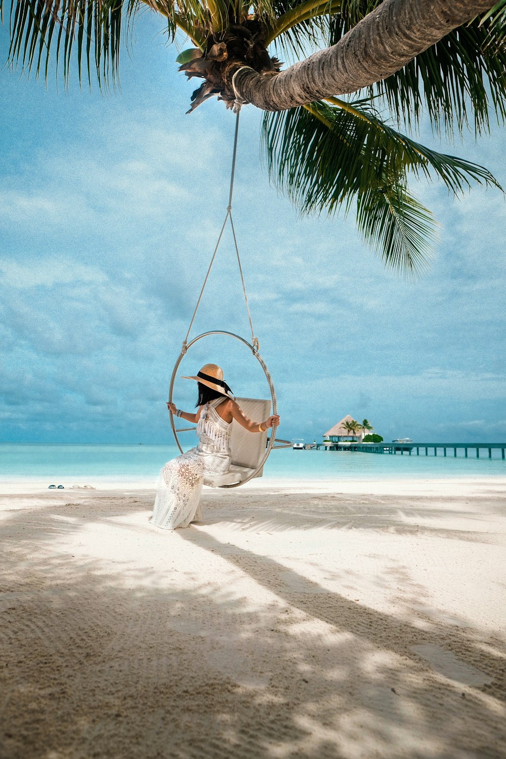 woman in white dress sitting on swing