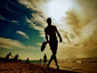 Sunset silhouette of a player holding a paddle, Game On Pickleball logo visible on their shirt.