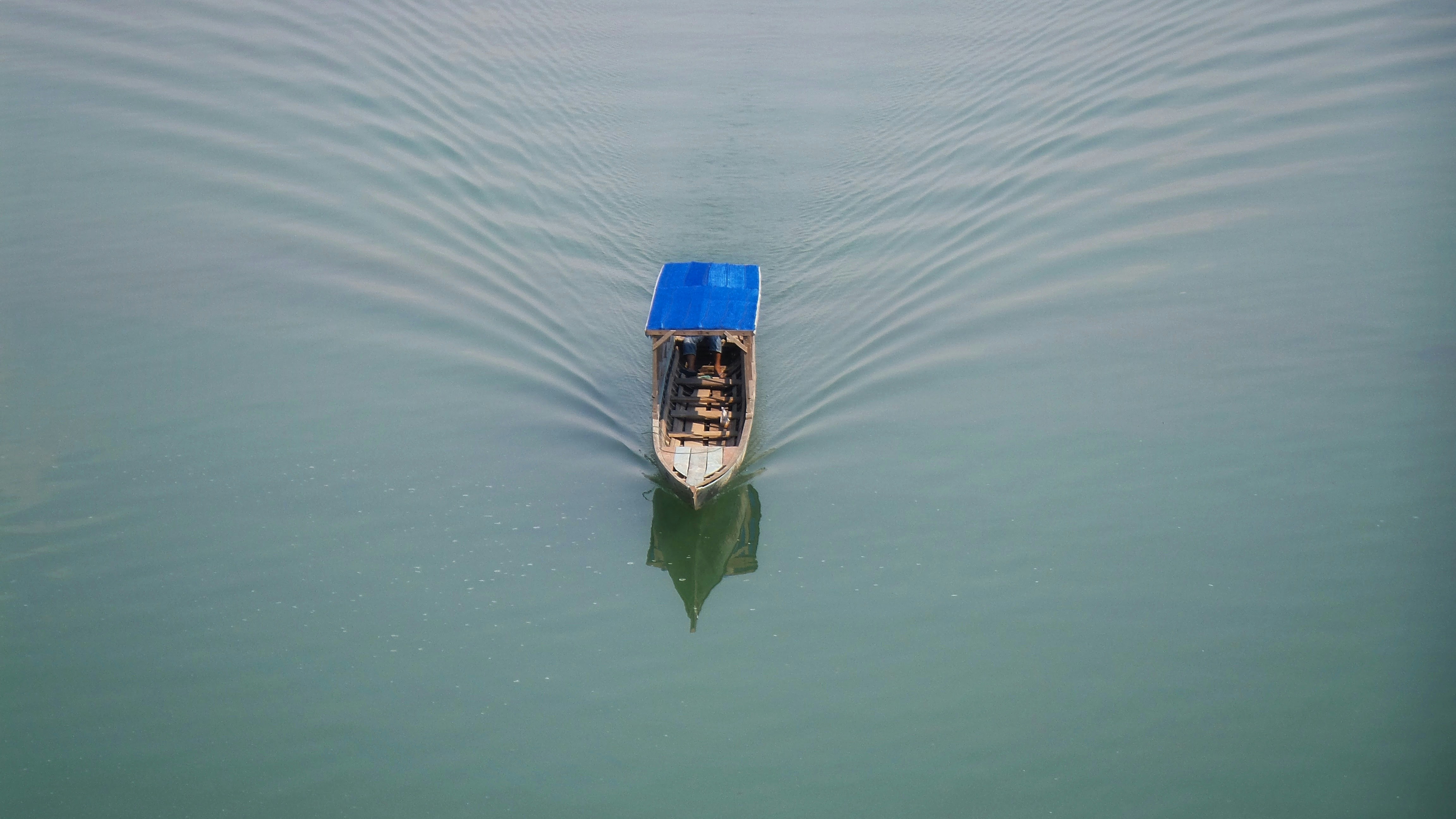 white and blue wooden canoe boat