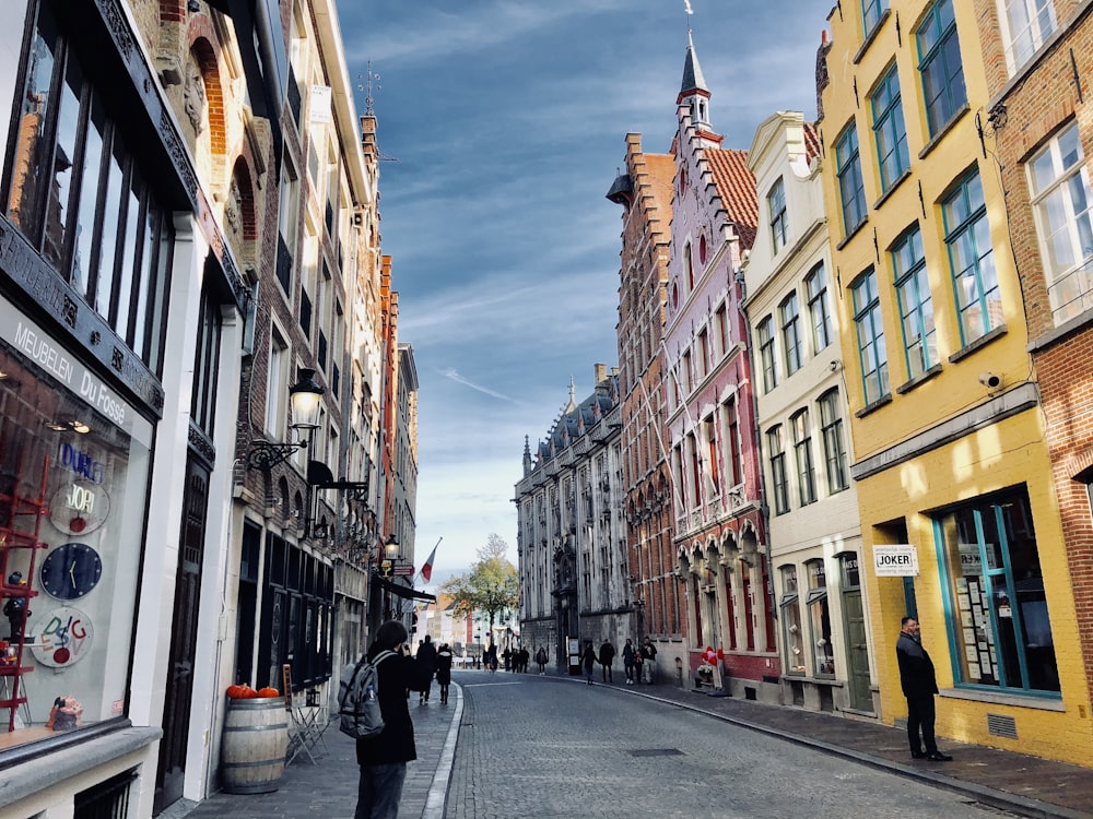 Gente caminando por la acera al lado de los edificios