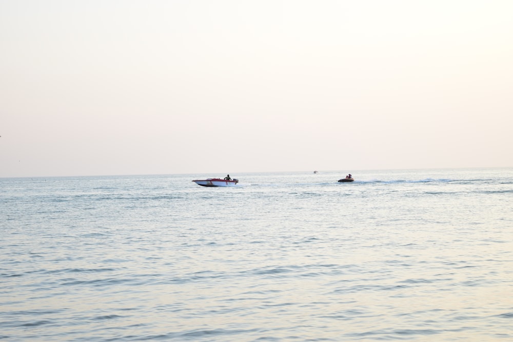 white and red boat in the middle of ocean