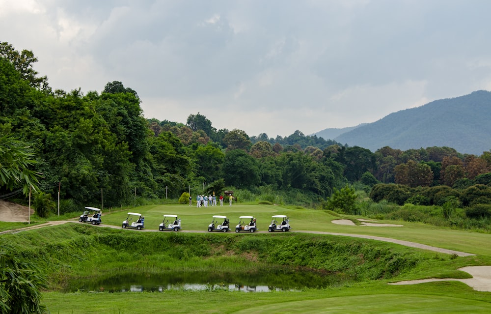 six white golf carts on field during daytime