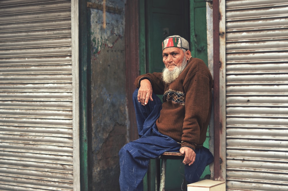 man sitting near roller shutter