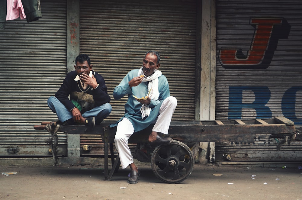 two men sitting on cart