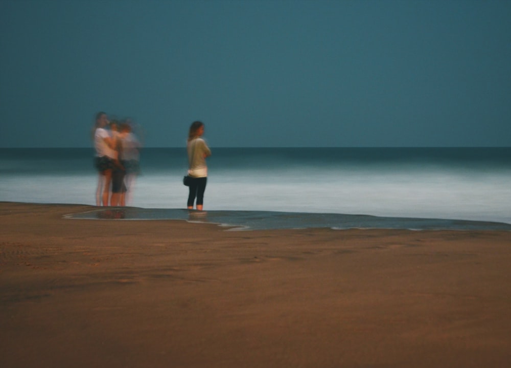 women standing on seashore