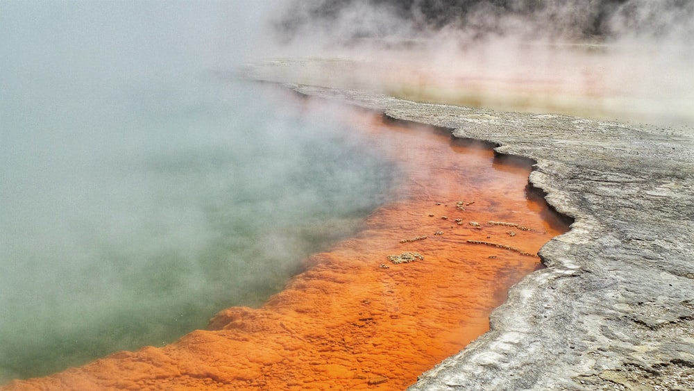 a body of water with steam rising from it