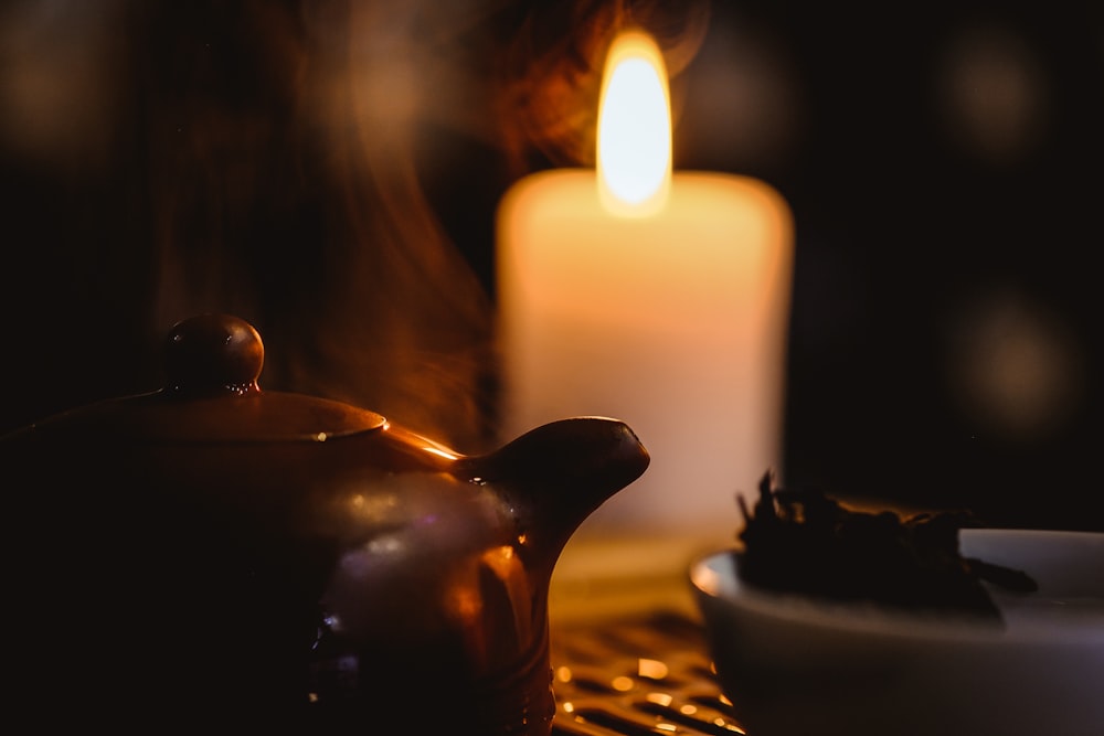 pillar candle and brown teapot