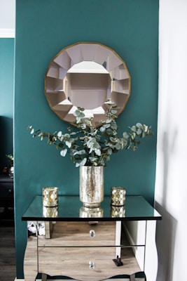 Decorative round mirror elegantly installed above a beige console table in a cozy living room