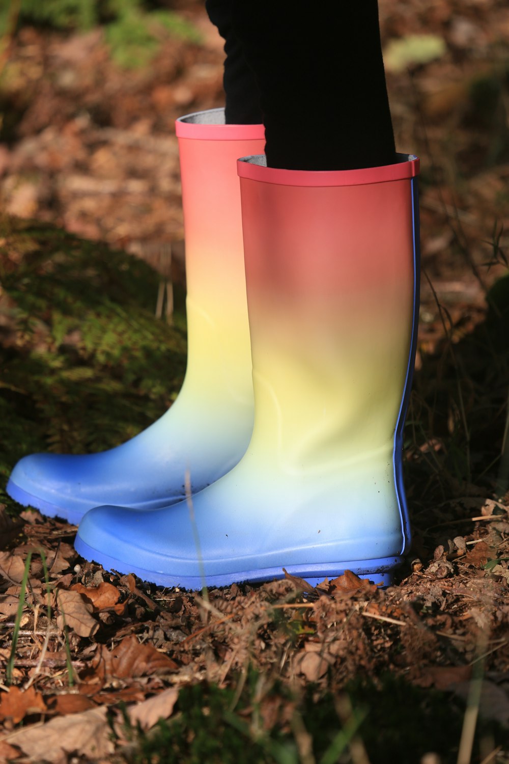 personne portant des bottes de pluie multicolores