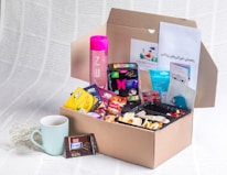 A care package filled with comforting items like cozy socks, tea, and encouraging notes.