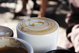 Close-up of a steaming cup of Karis Mushroom Coffee with visible swirls of creamy coconut milk.
