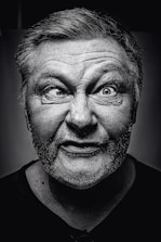 grayscale photography of man making silly face