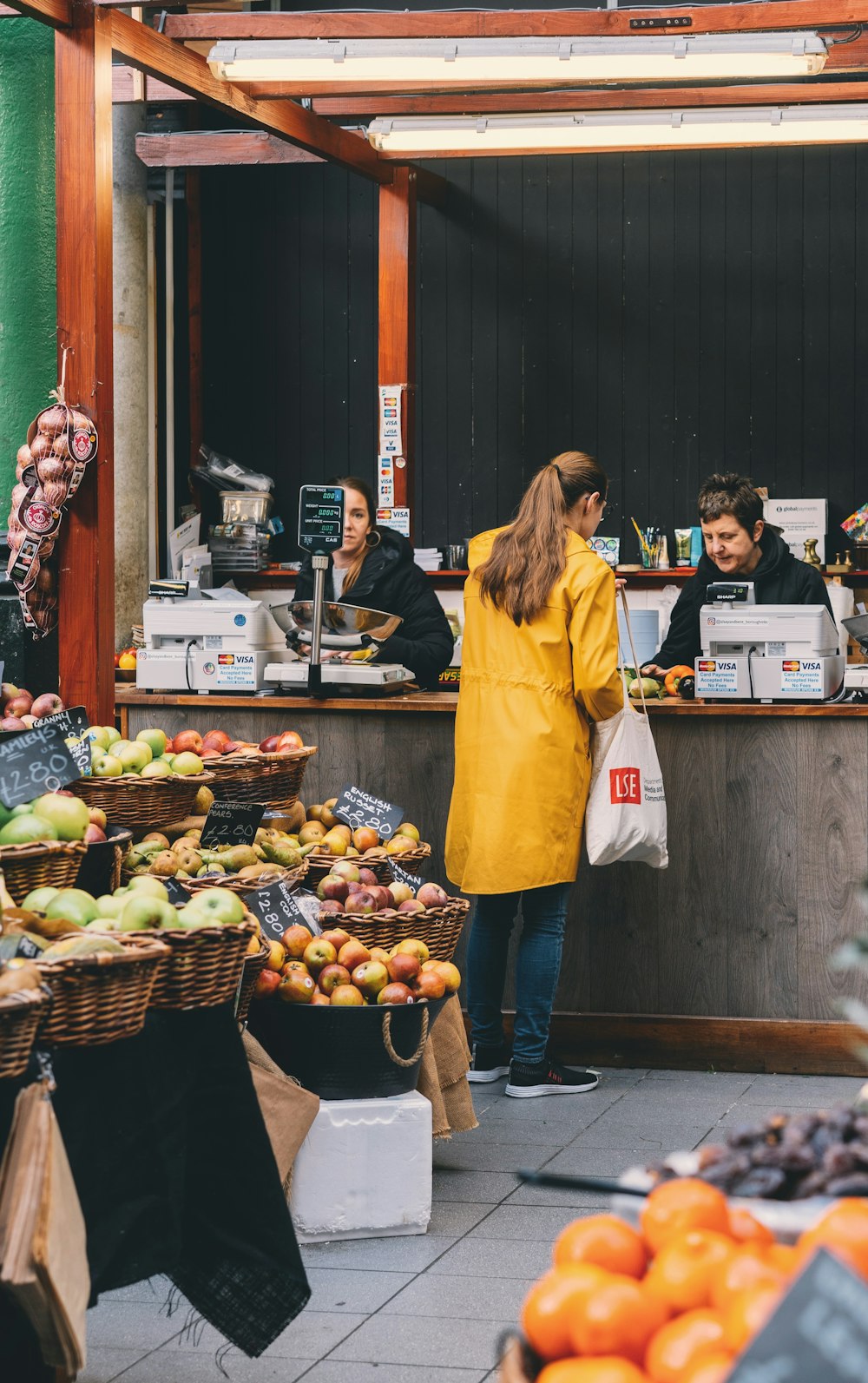 femme à la caissière à l’intérieur du magasin de fruits et légumes