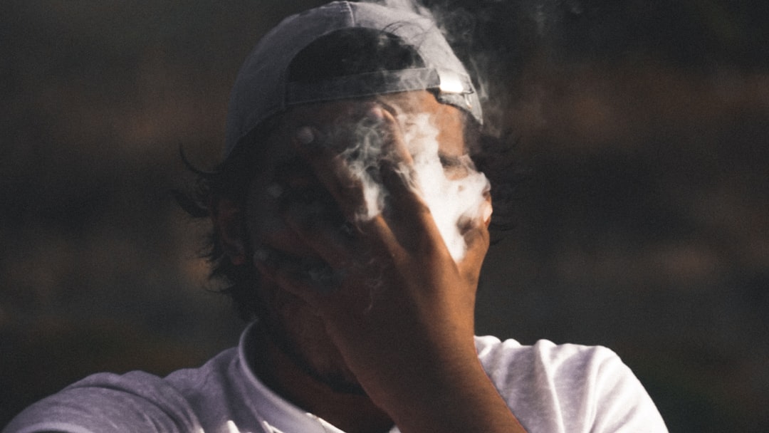 man covering smoke on face