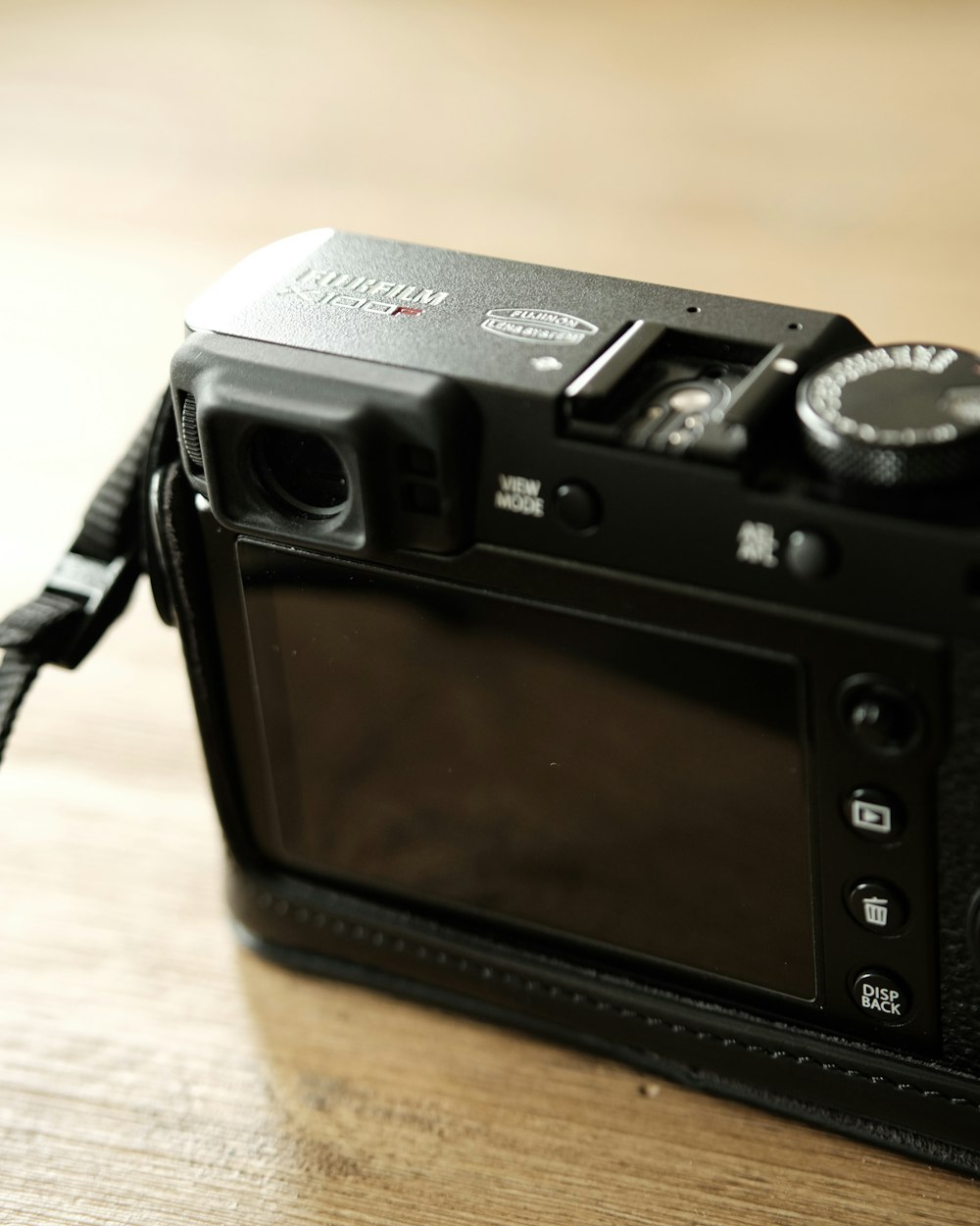black Fujifilm camera on brown surface