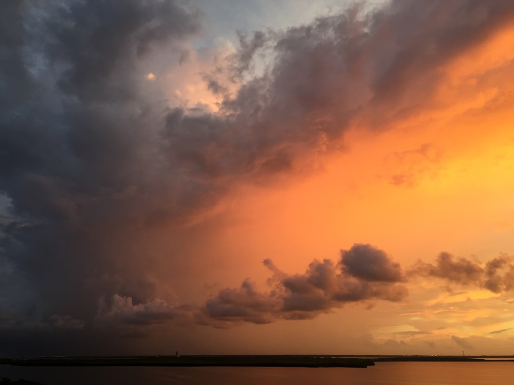 a sunset view of clouds over a body of water