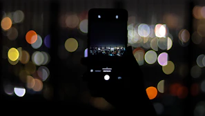 Activist confidently holding the Andr Phone against a backdrop of city lights at night