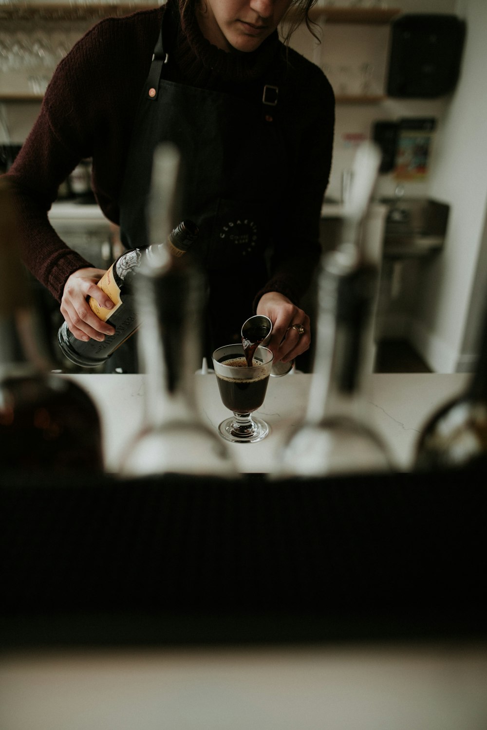 a woman pouring a drink into a glass