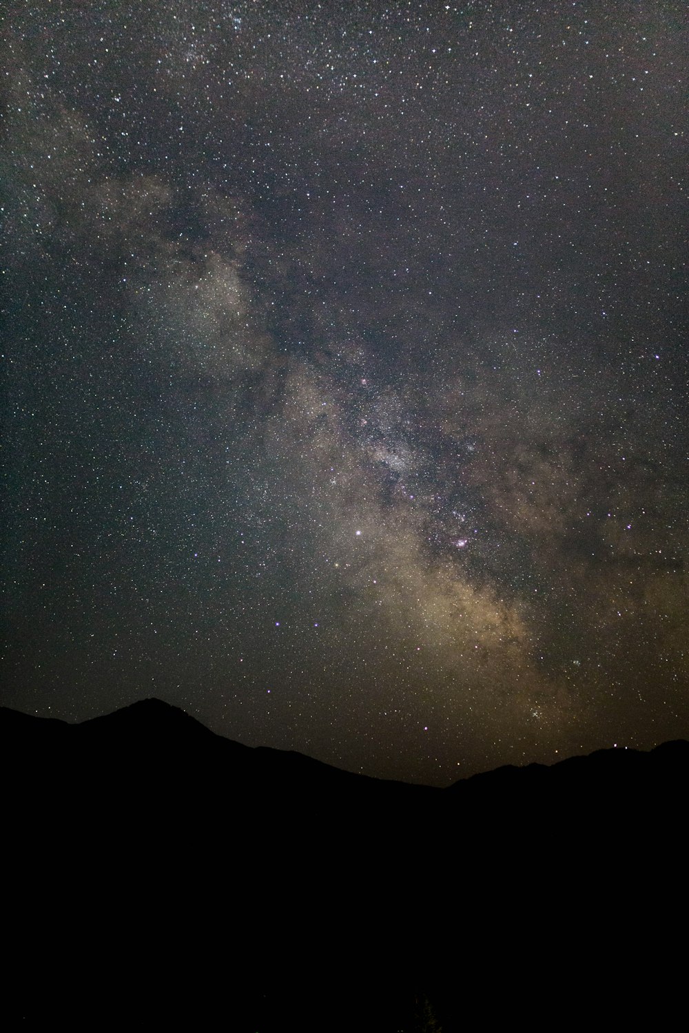 silhouette of mountain under stars