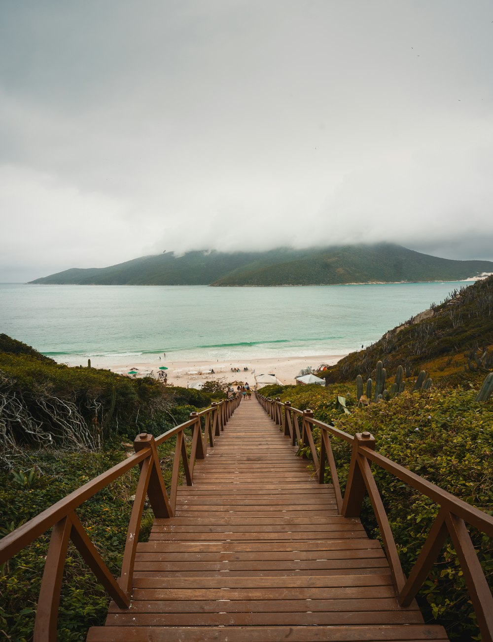 brown wooden stairs towards sand seashore during day