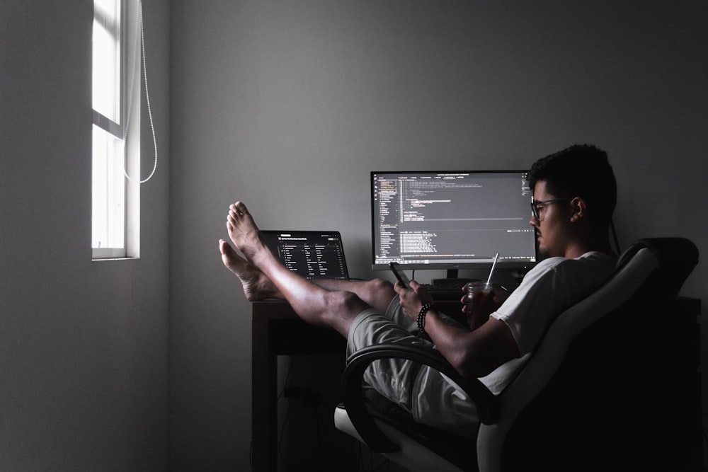 man sitting on chair infront of computer