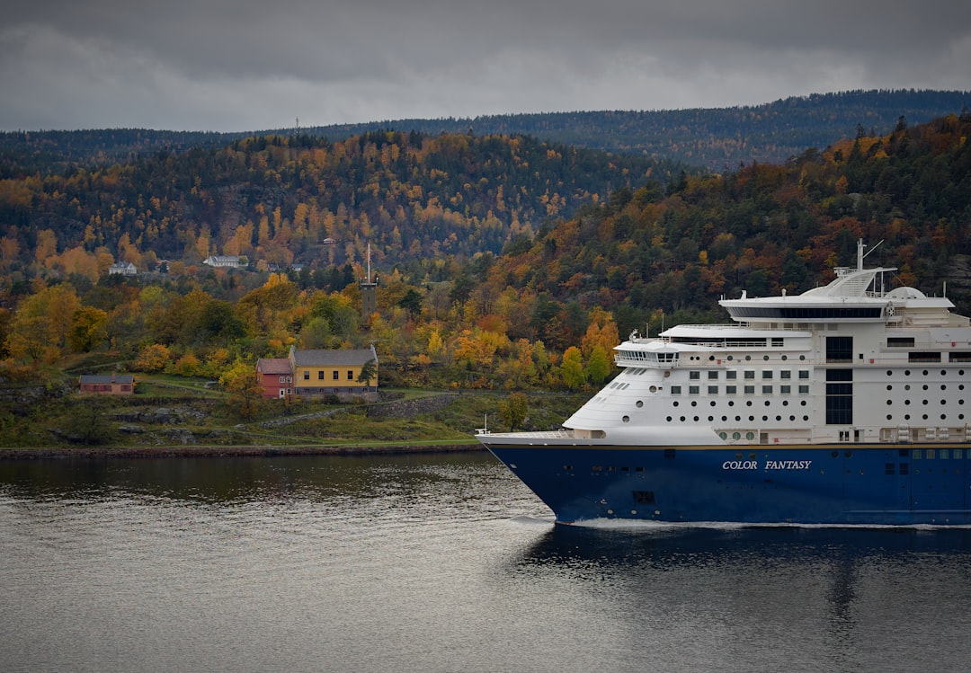 blue and white passenger vessel on calm body of water